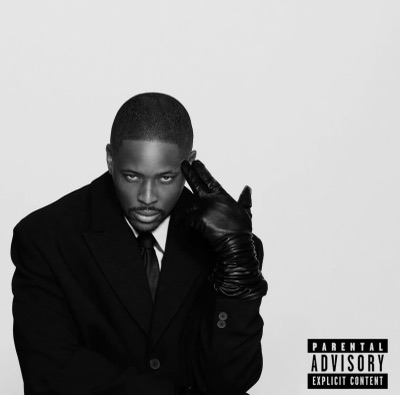 Black-and-white studio portrait in a suit and leather glove