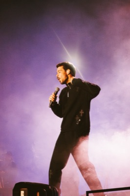Singer performing in purple stage fog
