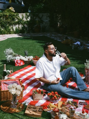 Man sipping champagne at a strawberry picnic