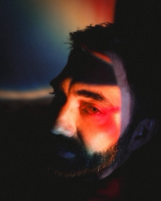 Portrait lit by projector light in red and blue